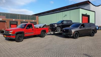 Container gelost met een Cadillac Escalade 6,2 L V8 SUV Sport Platinum en een GMC Sierra Carbon Pro 6,2 L V8 pick-up bedrijfswagen.